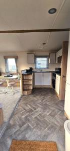an empty room with a kitchen and a table at Abi Summer Breeze - West Sands in Selsey