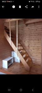 a wooden bunk bed with a ladder in a room at Domek u Beaty 1 in Rewal