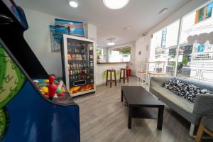 a living room with a couch and a refrigerator at Be Happy Hostel - Albergue en el centro de Nerja in Nerja