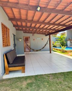 a patio with a hammock under a wooden pergola at Recanto Celestino 3 in São Miguel do Gostoso
