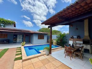 a patio with a swimming pool and a house at Recanto Celestino 3 in São Miguel do Gostoso