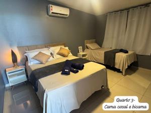 a bedroom with two beds and a fan at Recanto Celestino 3 in São Miguel do Gostoso +40 photos
