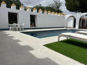 un cortile con piscina e recinzione bianca di Cortijo Las Cruces Guillena - Sevilla a Guillena