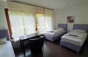 a room with two beds and a desk and a table at Apartment bei Hamburg bis 10 Personen mit Terasse und Gartennutzung. in Buchholz in der Nordheide