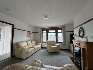 a living room with a couch and two chairs at Sea Road Retreat - Great for contractors in Methil