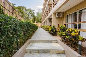 a walkway in front of a building with plants at Condomínio Eclipse Village, Praia de Juquehy in São Sebastião