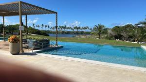 a swimming pool with a view of a lake at Costa do Sauípe - Reserva Sauípe in Costa do Sauipe