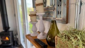 a table with two candles and a bottle of wine at Romantic colonial lodge with hot tub in Baddiley +14 photos