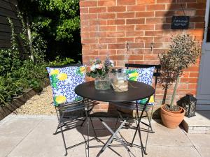 a table and two chairs with flowers on a patio at Cliff Cottage in Canford Cliffs