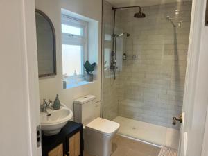 a bathroom with a shower and a toilet and a sink at Cliff Cottage in Canford Cliffs