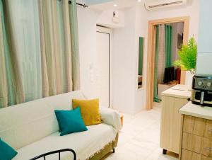 a living room with a white couch with colorful pillows at Kellys Corfu Apartments 3 in Corfu International Airport I Kapodistrias +8 photos