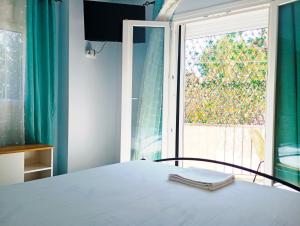 a bedroom with a bed and a large window at Kellys Corfu Apartments 3 in Corfu International Airport I Kapodistrias