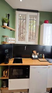 Una cocina con gabinetes blancos y una encimera de madera. en Studio de charme climatisé Gare Riquier, en Niza