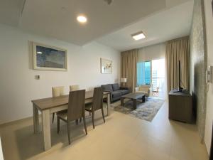 アブダビにあるPanoramic Seaview one-bedroom apartmentのテーブルと椅子とソファのあるリビングルーム