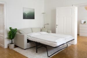 a white couch sitting in a living room at Bright City Apartment in Graz +11 photos