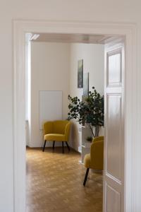 a room with two yellow chairs and a plant at Bright City Apartment in Graz