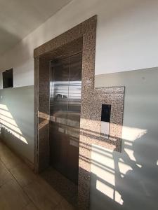 a building with a door with a shadow on the wall at Acehomes Studio in Kinoo