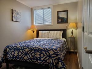 a bedroom with a blue and white bed with two lamps at Gray Goose - Close to Falls & Casino in Niagara Falls