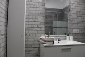 a bathroom with a white sink and a brick wall at Casa El Pajar in Breña Alta +47 photos