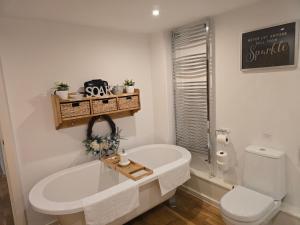 a white bathroom with a tub and a toilet at The Granary House - Long Stayz in Plymouth +50 photos