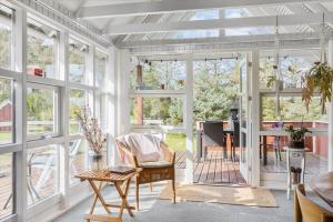 a conservatory with a table and chairs and windows at LL204-Humble-Vildrosevej-16 in Humble