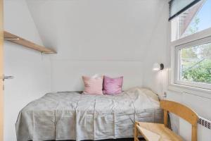 a bedroom with a bed with pink pillows on it at LL204-Humble-Vildrosevej-16 in Humble