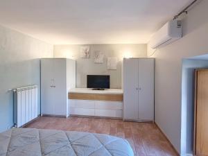 a bedroom with white cabinets and a television in it at Casa Vacanze ad Ariccia vicino Roma e ai Laghi - La Riccia Holiday Home - in Ariccia +6 photos