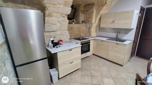 a kitchen with wooden cabinets and a stainless steel refrigerator at La Casa del Colosso in Barletta