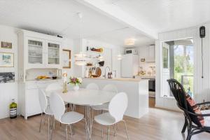 a kitchen and dining room with a white table and chairs at LL252-Humble-Laxtonvej-36 in Humble