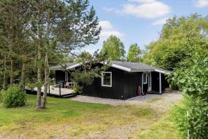 a black house in the middle of a yard at LL252-Humble-Laxtonvej-36 in Humble +21 photos