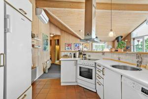 a large kitchen with white appliances and wooden ceilings at LL209-Humble-Ristingevej-141-A in Humble +13 photos