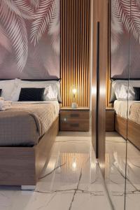 a bedroom with two beds and a wall with palm leaves at Garda Lake Holiday Apartments Trilocale in Cavalcaselle