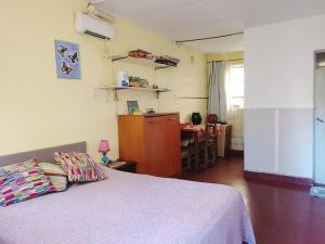 a bedroom with a bed and a table and a kitchen at Tiny-house in Concordia