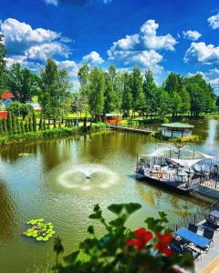 a boat is docked on a river with a fountain at Pokoje Gościnne Pod Złotym Pstrągiem in Zgorzelec