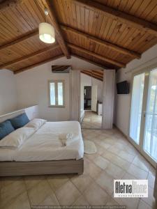 a bedroom with a large bed with a wooden ceiling at ALETNA Home in Ragalna
