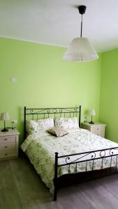 a bedroom with a bed with a green wall at Locanda La Tana Del Luppolo in Valmadrera