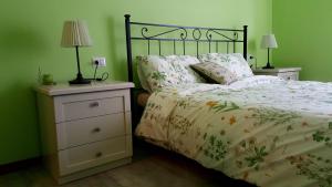 - une chambre avec un lit et une table de nuit avec deux lampes dans l'établissement Locanda La Tana Del Luppolo, à Valmadrera