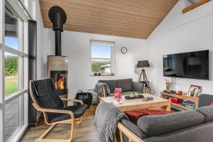a living room with a couch and a fireplace at C11322-Tarm-Sivsangervaenget-49 in Tarm