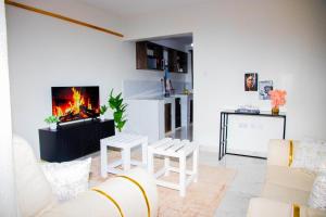 un soggiorno con camino e 2 sedie bianche di Riftview haven homes a Eldoret Altre 15 foto
