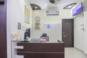 an office with a reception desk and a clock on the wall at Hotel O Shyam Vatika Banquet And Rooms in Surat