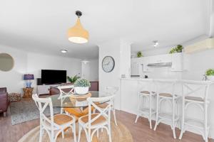 a kitchen and living room with a table and chairs at Heritage 401 in Tuncurry