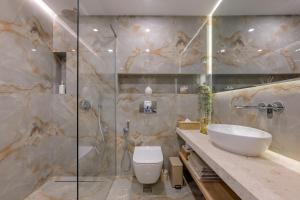 a bathroom with a toilet and a sink and a shower at Luxury Sea View Appartment with Beach Access - Parking & Heated Pool in Varna City