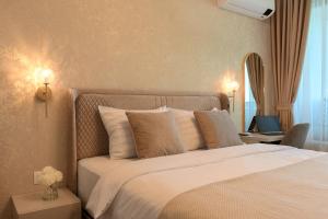 a bedroom with a large bed with white sheets and pillows at Luxury Sea View Appartment with Beach Access - Parking & Heated Pool in Varna City