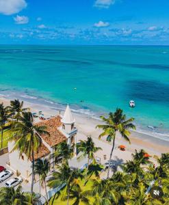 an aerial view of a resort on a beach with palm trees at Flat Mar de Campas Beach Tamandaré in Tamandaré +47 photos