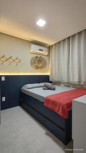 a bedroom with a bed with a red blanket at Flat Mar de Campas Beach Tamandaré in Tamandaré