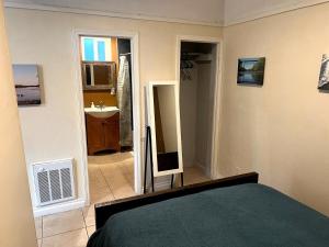 a bedroom with a bed and a bathroom with a mirror at OB Getaway Fenced Yard, Walk to Beach & Cafes in San Diego