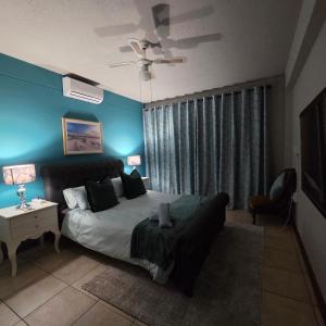 a bedroom with a bed and a couch and a ceiling fan at Bekk-bur in Potchefstroom