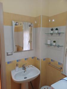 a bathroom with a sink and a mirror at La Lanterna Apartment in Canicattì +4 photos