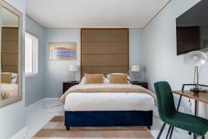 ケープタウンにあるLagoon Shoreline Penthouseのベッドルーム1室(ベッド1台、デスク、椅子付)