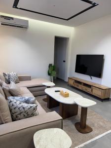 a living room with a couch and a flat screen tv at نوفا للشقق الفندقية in Jeddah